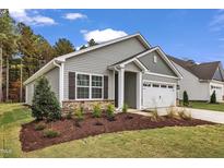 Charming single-story home boasts manicured landscaping, stone accents, and an attached garage at 208 Brickwell Way, Youngsville, NC 27596