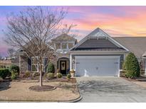 Charming single-story home featuring stone accents, a well-manicured lawn, and an attached two-car garage at 221 Elverson Pl, Cary, NC 27519