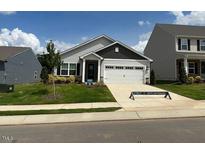 Charming one-story home featuring a two-car garage and a well-manicured front yard at 305 Brickwell Way, Youngsville, NC 27596