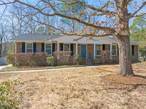 Charming brick home with a cozy front porch and mature trees in a well-landscaped yard at 400 Highview Dr, Chapel Hill, NC 27517