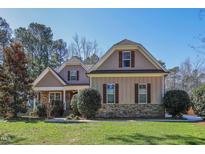 Charming home featuring stone accents, a manicured lawn and mature trees in a desirable neighborhood at 5105 Watkinsdale Ave, Raleigh, NC 27613