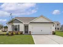 Charming one-story home with a two-car garage, well-manicured lawn, and stone accents at 605 Benton Dr, Oxford, NC 27565