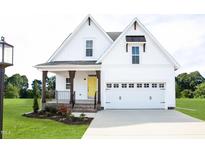Charming two-story home with white siding, a yellow front door, and a well-manicured lawn at 619 Magnolia Acres Ln, Fuquay Varina, NC 27526