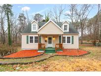 Charming single-Gathering home with a cozy front porch, green shutters, and landscaped yard at 673 Beck Ave, Henderson, NC 27536