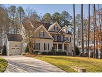 Two-story home boasts a manicured lawn and a stone and siding facade with a welcoming front porch at 6824 Palaver Ln, Cary, NC 27519