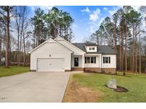 Charming white two-story home with a well-manicured lawn and attached two car garage at 9230 Bear Run Ln, Middlesex, NC 27557