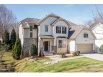 Charming two-story home featuring a manicured lawn, stone accents, and attached two car garage at 101 Owensboro Ct, Raleigh, NC 27603