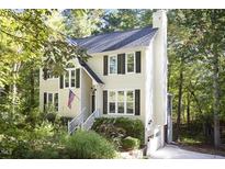 Charming two-story traditional home with light yellow siding, black shutters, and a well-manicured front yard at 1402 Princess Anne Rd, Cary, NC 27513