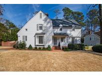 Charming white two-story home with a well-manicured lawn and inviting brick walkway at 1502 Iredell Dr, Raleigh, NC 27608