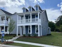 Charming two-story home featuring a covered front porch and three dormer windows at 304 White Oak Garden Way # 214, Garner, NC 27529