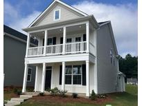 Charming two-story home featuring a double-stacked porch, gray siding, and landscaped front yard at 308 White Oak Garden Way # 215, Garner, NC 27529