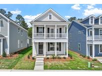 Charming two-story home boasts a welcoming porch and upper balcony, perfect for enjoying the neighborhood views at 308 White Oak Garden Way # 215, Garner, NC 27529