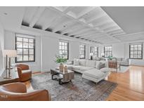 Bright living room featuring hardwood floors, exposed beams, and multiple windows for plenty of natural light at 312 N Buchanan Blvd # 302, Durham, NC 27701