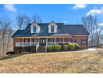 Charming brick home with a welcoming front porch and dormer windows under a clear blue sky at 4639 Reid Rd, Elon, NC 27244