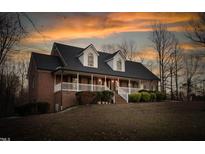 Charming brick home boasts a welcoming front porch, perfect for relaxing evenings at 4639 Reid Rd, Elon, NC 27244