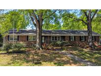 Charming brick home with a landscaped front yard, mature trees, and a welcoming entrance at 610 Westbrook Dr, Burlington, NC 27215