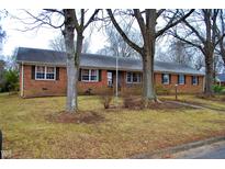 Charming one-story brick home with a well-maintained front yard and mature trees at 610 Westbrook Dr, Burlington, NC 27215