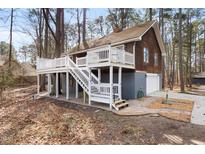 Charming elevated home featuring a beautiful white deck and exterior wood siding at 701 Black Pearl Cv, Rocky Mount, NC 27804