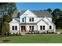 Stunning new two-story white home with beautiful stone accents and professionally landscaped front yard at 83 Stickleback Dr, Willow Springs, NC 27592