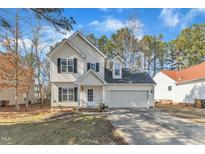 Charming two-story home with a well-manicured lawn and attached two car garage at 112 Wellspring Dr, Holly Springs, NC 27540