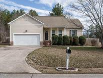 Charming single-story home with a well-maintained front yard and attached two-car garage at 1219 E Middleton Dr, Creedmoor, NC 27522