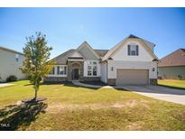 Charming home with a well-manicured lawn and a welcoming two-car garage at 156 Bornean Dr, Garner, NC 27529