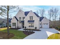 Stunning two-story home with cream-colored brick, a paved driveway, and manicured lawn at 162 Lookout Rdg # 677, Pittsboro, NC 27312