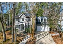 Beautiful gray two-story home featuring an attached two-car garage and professionally landscaped yard at 205 Oxford Hills Dr, Chapel Hill, NC 27514