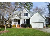 Charming two-story home featuring a covered porch, well-maintained lawn, and attached garage at 2213 Oakhurst Trl, Hillsborough, NC 27278
