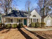 Charming single-story home with a welcoming front porch and mature landscaping on a sunny day at 308 Trimble Ave, Cary, NC 27511