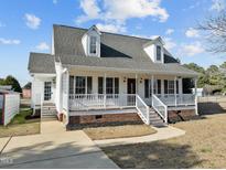 Charming two-story home boasts a welcoming front porch, dormer windows, and professionally landscaped yard at 345 Lafayette Rd, Fuquay Varina, NC 27526