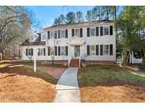 Traditional two-story white home with black shutters and a welcoming front porch and landscaped front yard at 4301 Brookshire Rd, Durham, NC 27707