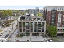 Modern condo building with brick and black accents, featuring balconies and garage doors at 615 W Peace St # 406, Raleigh, NC 27605