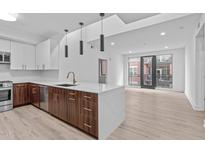 Open kitchen with modern white countertops, stainless steel appliances, and spacious living area at 615 W Peace St # 406, Raleigh, NC 27605