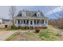 Charming home featuring a welcoming front porch, dormer windows, and a well-manicured lawn at 802 N Fifth St, Mebane, NC 27302