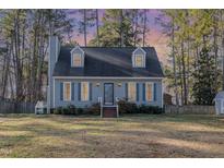 Charming blue two-story home with dormers, blue shutters and a brick front porch at 104 Tyser Pl, Garner, NC 27529