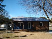 Cozy single-story home featuring a mix of brick and blue siding under a bright blue sky at 110 N 8Th St, Erwin, NC 28339