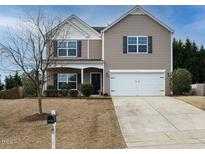 Charming two-story home with a well-manicured lawn and attached two-car garage at 1113 Crendall Way, Wake Forest, NC 27587