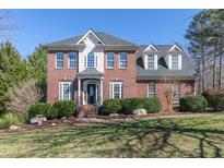 Charming two-story red brick home featuring manicured landscaping and a classic architectural design at 1154 Smith Creek Way, Wake Forest, NC 27587