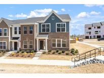 New two-story brick townhome with a landscaped yard and a modern design at 203 Frosted Iris Lane St # 181, Garner, NC 27529