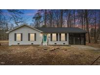 Charming single-story home featuring a white brick facade, black shutters, and an attached screened-in porch at 2232 Miller Rd, Hillsborough, NC 27278