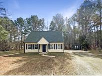 Charming single Gathering home featuring a manicured front lawn and a private lot surrounded by mature trees at 26 Malbry Pl, Durham, NC 27704