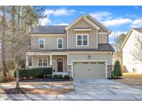 Charming two-story home featuring a well-manicured lawn, attached two car garage and covered front porch at 2938 Suncrest Village Ln, Raleigh, NC 27616