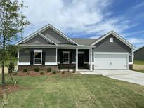 Charming single-story home with gray siding, a two-car garage, and manicured lawn at 316 Olivia Crossing Ct # 11, Four Oaks, NC 27524