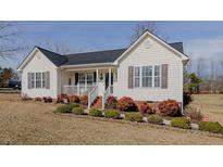 Charming single-story home featuring manicured landscaping, a welcoming front porch, and classic design at 3545 Westmeadow Ln, Elon, NC 27244
