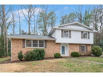 Charming two-story home featuring brick facade, white siding, shuttered windows, and landscaped yard at 4905 Brookhurst Pl, Raleigh, NC 27609