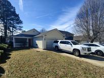 Charming single-story home with a screen porch, attached garage, and well-maintained front yard and driveway at 5836 Bryanstone Pl, Raleigh, NC 27610