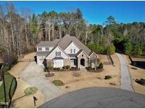 Aerial view of a charming two-story home with a circular driveway and well-manicured landscaping at 809 Rockhouse Ct, Cary, NC 27519