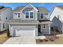Charming two-story home with gray siding, a two-car garage, and manicured landscaping at 88 Antler Steel Dr, Clayton, NC 27527