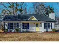 Charming single-story home featuring a welcoming yellow door, blue shutters, and a well-maintained yard at 1044 Willie Gray Rd, Timberlake, NC 27583